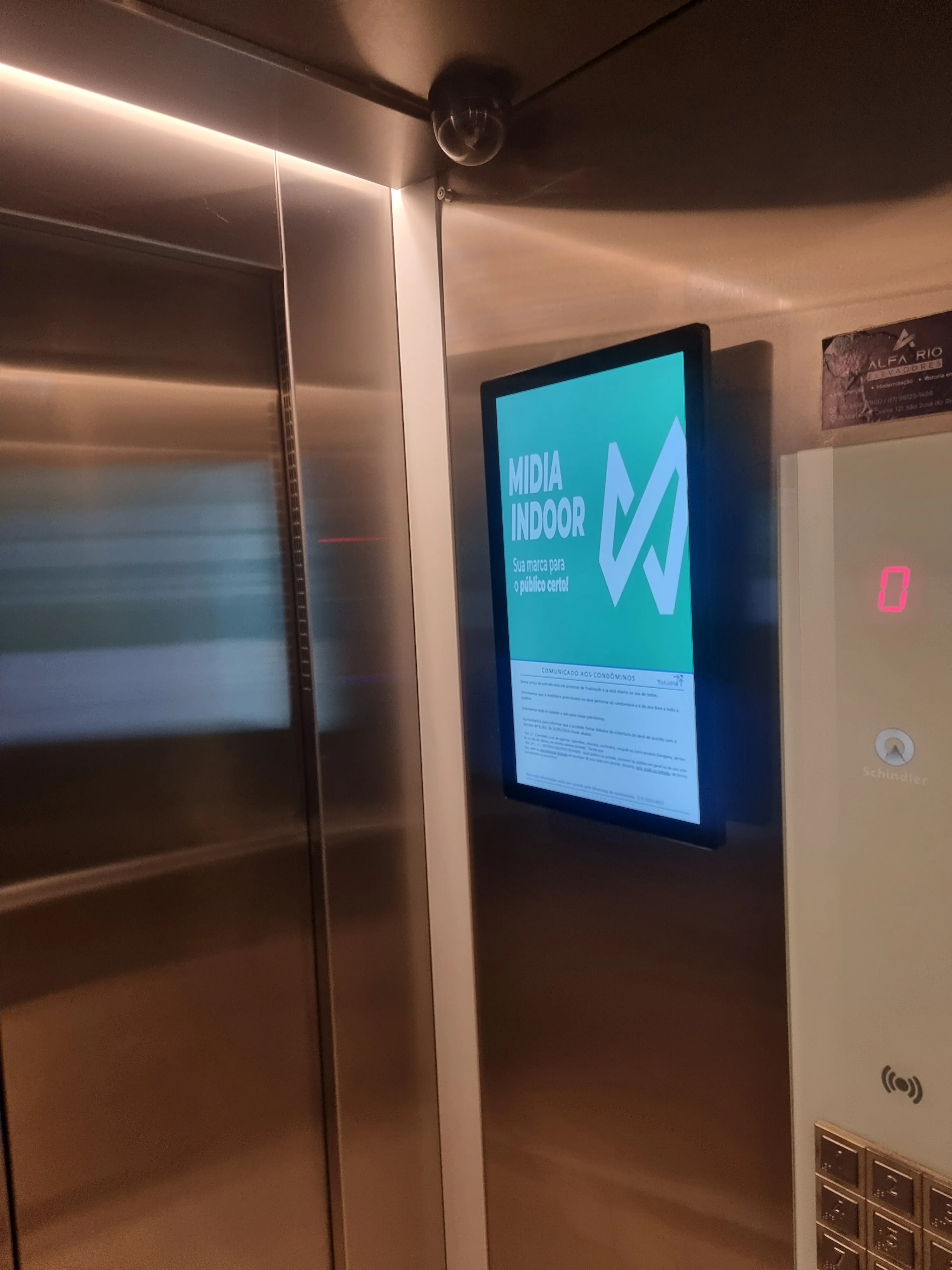 Tela 22” em elevador residencial — mídia indoor